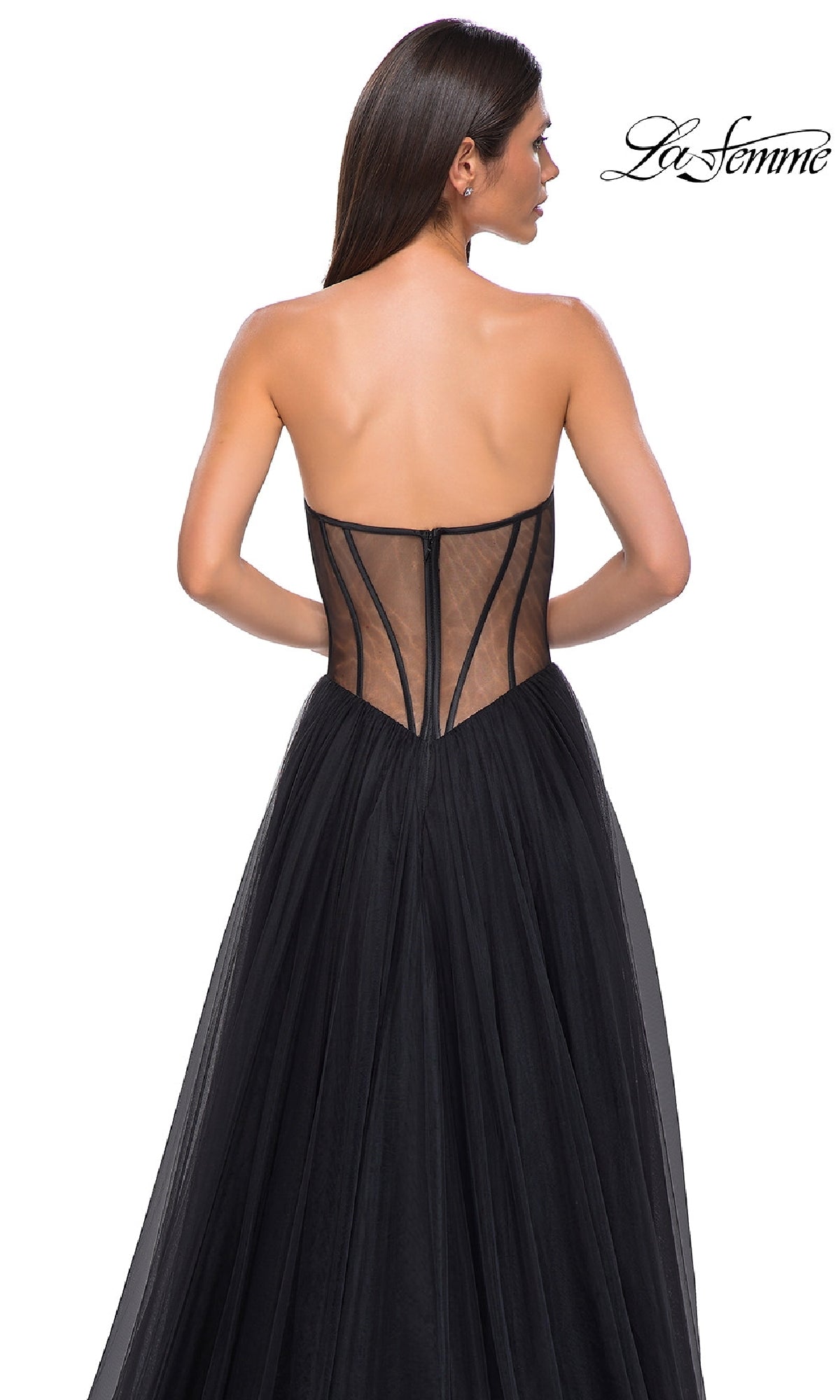 A woman wears the La Femme 32771 black strapless long prom dress with a sweetheart neckline, sheer corset-style back, and flowing tulle skirt, standing against a white background.